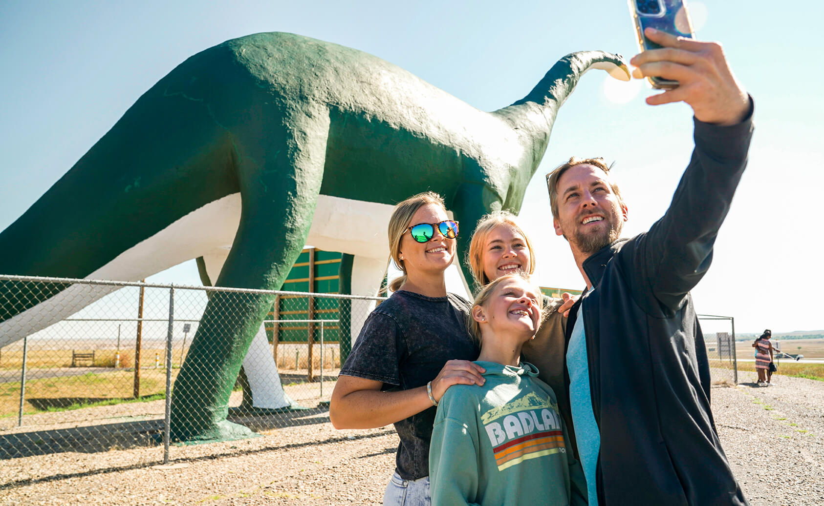 family taking selfie by 80 foot dinosaur