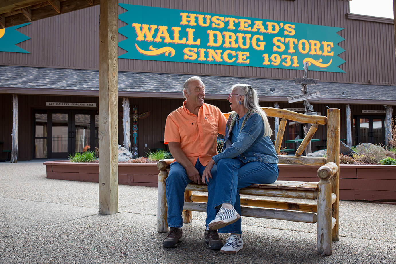 elderly couple sitting on bench near wall drug's back yard area