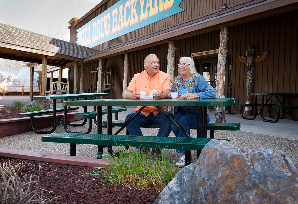 elderly couple sitting in wall drug's backyard area