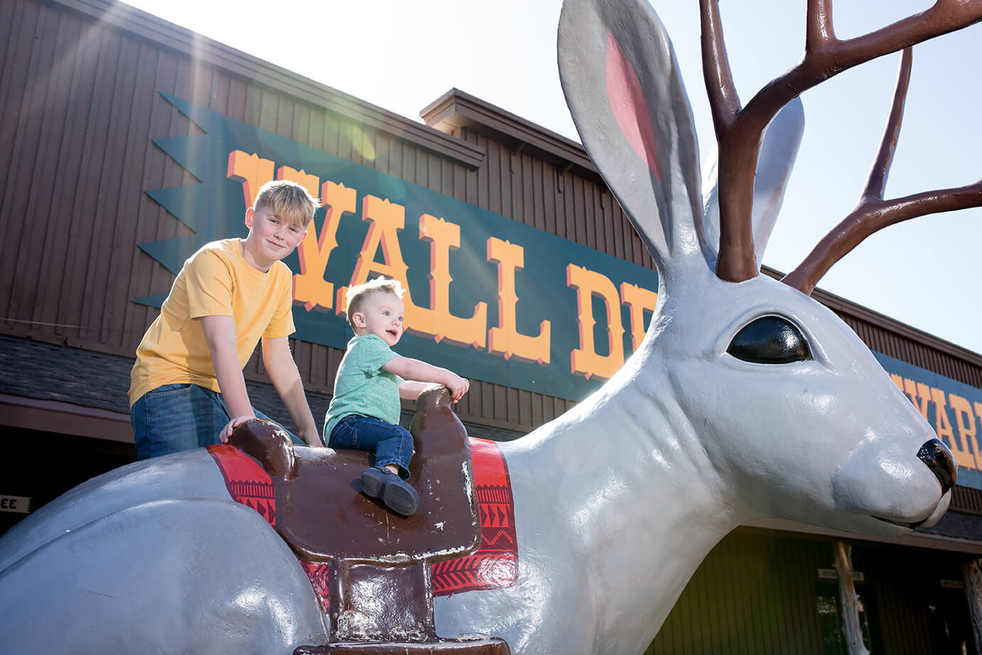 children riding the giant jackelope in wall drug's back yard